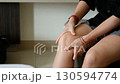 Asian woman hand holding knee in pain symbolizing joint injury arthritis or muscle strain 130594774