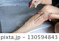 Woman hands massaging oil onto her legs for skin care hydration and beauty routine at home 130594843