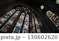 Camera tilts down stained glass window of Durham Cathedral to reveal modern statue in the Chapel of the Nine Alters  130602620