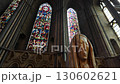 Camera tilts down stained glass window of Durham Cathedral to reveal modern statue in the Chapel of the Nine Alters  130602621