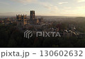 Drone circles Durham Cathedral, England during a stunning autumn sunrise. Mist is seen over the hills  130602632