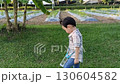 A bun hair toddler walking around the garden in sunset  130604582