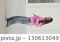 Girl in casual outfit performs playful dance gestures in front of a neutral wall. The dynamic live shooting style enhances authenticity, reflecting individuality and the vibrant spirit of youth. 130613049