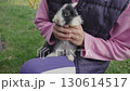 A girl is playing with a small rabbit sitting in her arms.  130614517