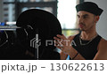 A skilled Fashion Stylist is analyzing apparel and accessories in a studio setting 130622613