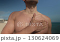 Man Applying Sunscreen to His Body at the Beach 130624069