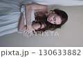 Portrait of a beautiful brunette with long hair on a fabric background in the studio. Beautiful natural woman posing for the camera 130633882