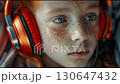 A close-up video of a teenager with headphones. A red-haired boy listening to music or working with headphones. 130647432