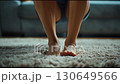 A video of a woman's legs standing up and starting walking. Close-up of a woman's legs rising from a sitting position. 130649566