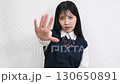 白背景の前でSTOPポーズをする女子高生 130650891