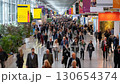 A bustling trade fair showcases a myriad of booths, with attendees networking amid the exhibition's vibrant environment, focusing on business and industry opportunities. 130654374