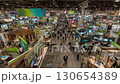 An expansive convention floor showcases a bustling trade show, filled with booths and a diverse crowd exploring the marketplace and industry innovations. 130654389
