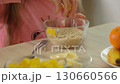 close-up of a girls hands preparing a bowl of cereal with fresh fruit, emphasizing healthy eating 130660566