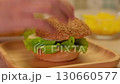 Hands preparing sandwich with cheese, tomato and lettuce for school snack top view 130660577