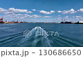 Drone footage of a ship returning to port in a vast coastal industrial area, where rust stands out in natural light. 130686650
