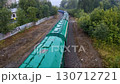On a summer cloudy day, hopper freight cars transport cargo by rail 130712721