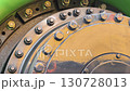 Close-up view of large industrial machinery showcasing bolts and metal components in a factory environment 130728013