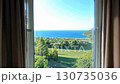 The large windows offer a view of the blue ocean and green park, and the open view is filled with soft morning light. 130735036