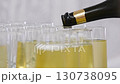 Champagne from the bottle is poured into glasses.  130738095