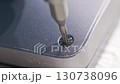close up. screwdriver and screw. A technician disassembles a laptop. 130738096