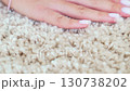 a woman's hand touching the beige Interior pile carpet made of polypropylene.  130738202