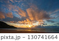 Time lapse A breathtaking sunset over a serene ocean beach, with vivid hues of orange, pink, and purple blending across the sky. Gentle waves roll onto the sandy shore, creating a peaceful coastal 130741664