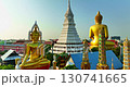 A striking aerial view of Bangkok featuring a golden Buddha statue and a white stupa surrounded by colorful temple rooftops, set against the backdrop of the modern city skyline. 130741665