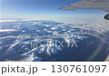 Aerial footage of snow-covered mountains seen from an airplane window creates a powerful and adventurous atmosphere 130761097