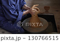 ろくろを使って器を形作る陶芸職人の手元 130766515