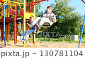Joyful Playtime Kids Enjoying Swings in a Colorful Playground Filled With Excitement 130781104