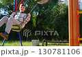 Children are having a wonderful time playing joyfully on the swings at the local park 130781106