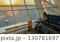 Teen waits at Baku airport while enjoying a book and watching the sunset 130781697