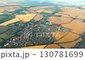 Aerial view of vibrant rural landscape featuring a small town surrounded by fields of golden crops and patches of green vegetation 130781699