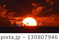 The sun glows green as it sinks into the sea 130807946