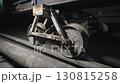 Steel wheels of rail cart shine faintly under dim light 130815258