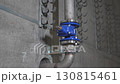 Steel pipe equipped with disk valve rests by concrete wall 130815461