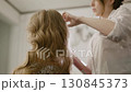 Combing hair, fixing with hairspray. Makeup artist stylist combing hair and spraying hairspray on it. Close-up 130845373