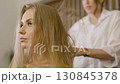 Hair drying. Caucasian hairdresser stylist make-up artist dries blows hair dryer long women hair 130845378