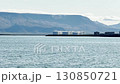 Seascape, horizon view of huge white tanks, oil and fuel storage facilities, mountain on the horizon, industrial Iceland landscape. 130850721