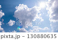 Timelapse of Fluffy White Clouds Moving Across a Bright Blue Sky with Shining Sunlight 130880635