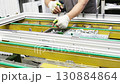 Factory worker assembling window frame components 130884864