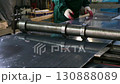 Metalworker bending sheet metal with bending machine 130888089