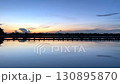 Beautiful sunset view over a calm lake with reflections of the sky and bridge on the water, creating a peaceful and romantic atmosphere in nature during twilight 130895870