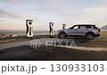 Electric SUV at a Peaceful Coastal Parking Lot with Futuristic Chargers 130933103