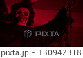 Close-up shot of a hooded skeleton reaper with a skull face under red light. Spooky Halloween decoration on a suburban house at night. 130942318