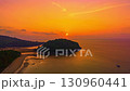 Aerial hyper lapse view of A stunning seascape capturing the vibrant colors of a dramatic sunset sky over a calm beach, Picturesque Tropical Sky at Sunset at Kala island Layan beach Phuket 130960441