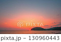 Time lapse Waves kiss the sandy beach while the fading sunlight creates a warm, romantic glow over the horizon. Serene Paradise Sunset by the Sea at Kala island Layan beach Phuket 130960443