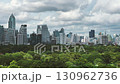 Sep 16 2025 - Bangkok, Thailand: Scene of High business building and the beautiful green park, the lung of people living in the capital city, Lumphini Public Park. Panning footage in high position. 130962736