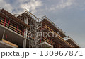 Construction Site with Scaffolding and Building Framework under Cloudy Sky Timelapse 130967871