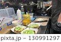 A chef prepares burgers in a cafe kitchen. 130991297